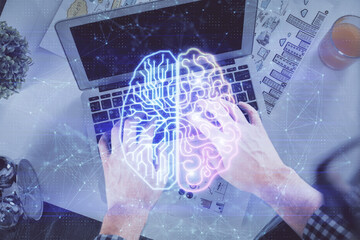 Double exposure of man's hands typing over computer keyboard and brain hologram drawing. Top view. Ai and data technology concept.
