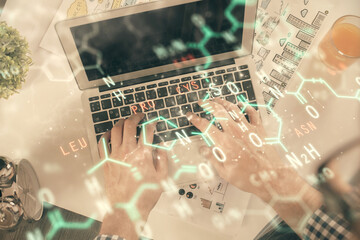 Double exposure of man's hands typing over computer keyboard and formula hologram drawing. Top view. Education concept.