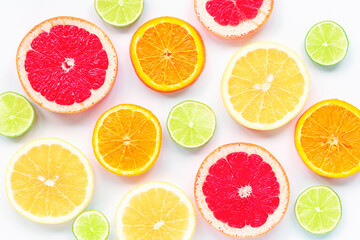 Fototapeta na wymiar Various sliced citrus fruits: lime, orange, red and yellow grapefruit on a white background, texture.