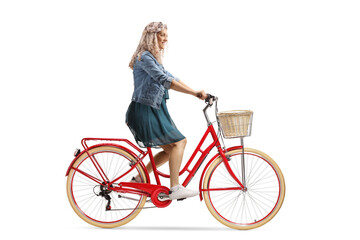 Blond young woman in a dress riding a red bicycle