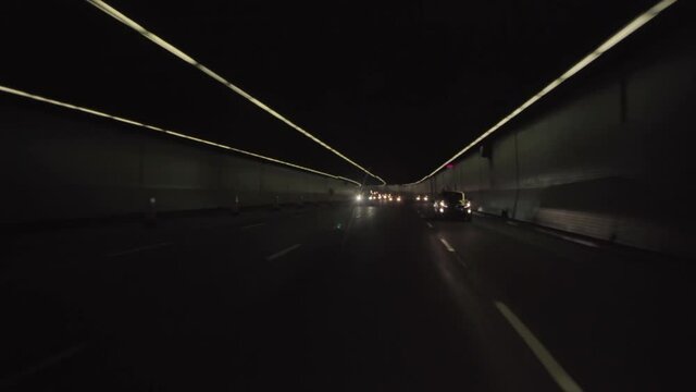 Montreal, Quebec, Canada - November 15, 2017: Car rear POV shot of vehicles on a dark tunnel road, filmed while driving on the 720 Highway.
