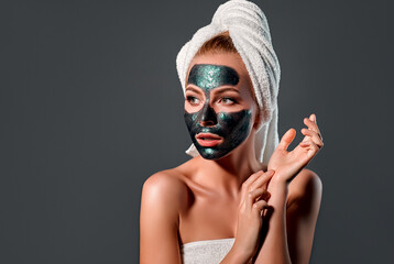 Beautiful woman with green peel-off mask on a gray background.