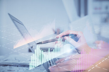 Multi exposure of woman hands typing on computer and financial graph hologram drawing. Stock market analysis concept.