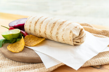 Mexican traditional authentic homemade Burrito with pulled pork beef chili con carne serve with tomato salad and avocado guacamole and dip sauce