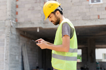 builder with van checking text messages on mobile phone