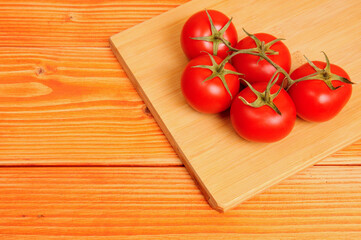 Red tomatoes on a wooden background