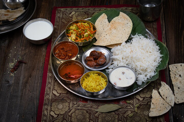 Indian vegetarian food served in thali style on wooden table, copy space