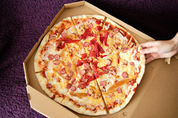 millennial woman takes a slice of delicious juicy healthy pizza