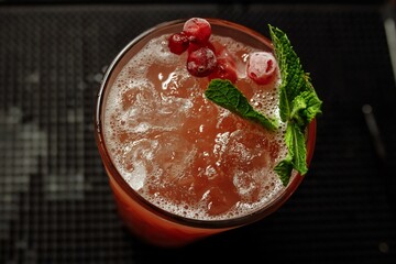 Cranberry summer lemonade decorated with mint on a bar counter