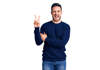 Fototapeta premium Young handsome man wearing casual clothes smiling with happy face winking at the camera doing victory sign. number two.