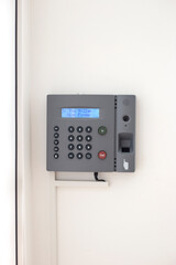 Small business biometric scanner. Electronic authorization equipment on the white wall, vertical orientation