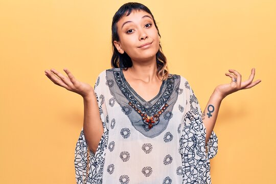 Young woman wearing casual clothes clueless and confused with open arms, no idea and doubtful face.