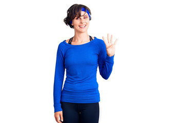 Beautiful young woman with short hair wearing training workout clothes showing and pointing up with fingers number four while smiling confident and happy.
