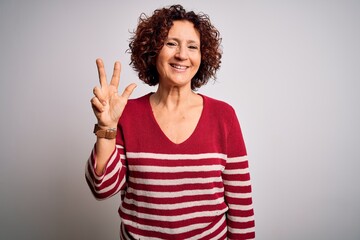 Middle age beautiful curly hair woman wearing casual striped sweater over white background showing...