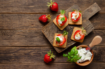 cutting board with fresh strawberry with cream cheese, balsamic vinegar and basil