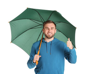 Handsome young man with umbrella showing thumb-up on white background