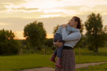 Motherhood, care, infants, summer, parenting concept - Young mom with with three year old little...