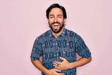 Young handsome hispanic bohemian man wearing hippie style over pink background smiling and laughing...