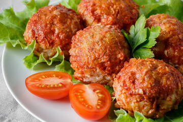 Homemade meat balls with vegetables in tomato sauce. Appetizing protein dish on a  plate.