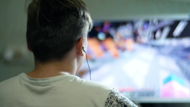 Teenager boy child controls the computer PC with the mouse and keyboard 