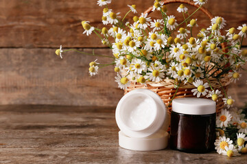 Obraz na płótnie Canvas Cosmetic cream chamomile flowers on wooden background