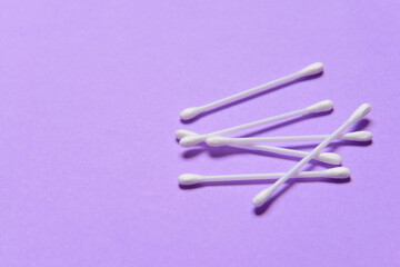 Cotton cosmetic swabs on color background