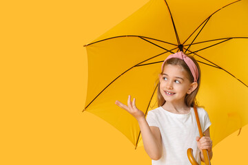 Cute little girl with umbrella on color background