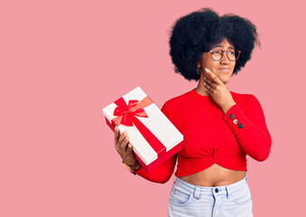 Young african american girl holding gift touching painful neck, sore throat for flu, clod and...