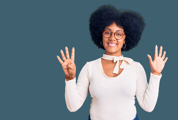 Young african american girl wearing casual clothes and glasses showing and pointing up with fingers...