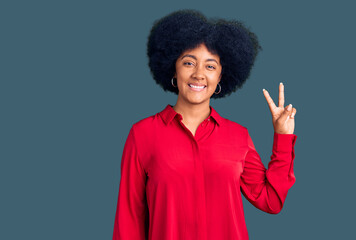 Young african american girl wearing casual clothes smiling looking to the camera showing fingers doing victory sign. number two.