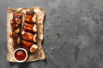 Tasty beef short ribs with sauce on dark background