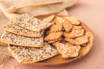Plate with cereal cookies on color background