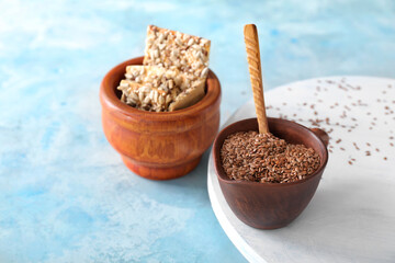 Bowl with cereal cookies and flax seeds on color background