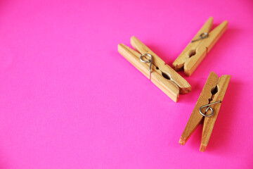 wooden clothes pins on pink background 
