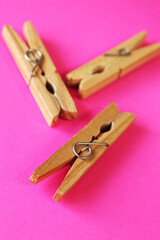 wooden clothes pins on pink background 