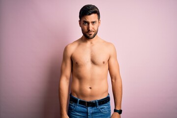 Fototapeta premium Young handsome strong man with beard shirtless standing over isolated pink background skeptic and nervous, frowning upset because of problem. Negative person.