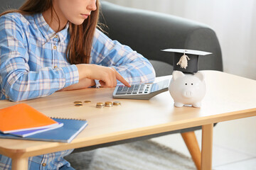 Teenage girl with savings for education and calculator at home
