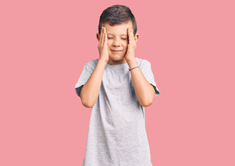 Cute blond kid wearing casual clothes suffering from headache desperate and stressed because pain and migraine. hands on head.