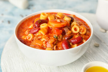 Bowl with tasty pasta and beans on table