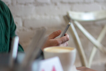 A person is using the phone in a cafe. 