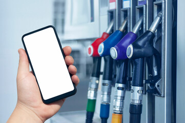 Mock up smartphone in hand closeup on the background of a gas station. Payment refueling online.