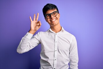 Young handsome business man wearing shirt and glasses over isolated purple background smiling positive doing ok sign with hand and fingers. Successful expression.