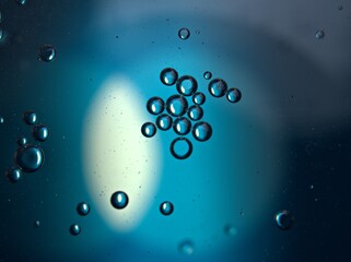Closeup bubbles oil in water with blue light blurred abstract background, macro image ,droplets for...