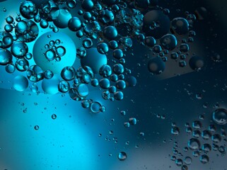 Closeup bubbles oil in water with blue light blurred abstract background, macro image ,droplets for card design	