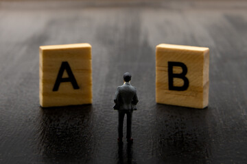 Miniature figurine posed as businessman making decision on Solution A versus B, minimalist abstract...