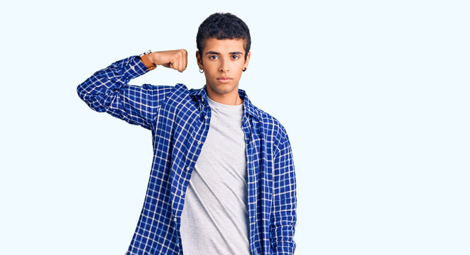 Young african amercian man wearing casual clothes strong person showing arm muscle, confident and proud of power