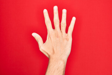 Hand of caucasian young man showing fingers over isolated red background counting number 5 showing five fingers