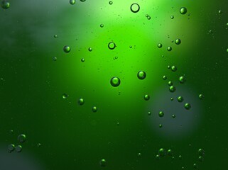 Closeup bubbles oil in water with green blurred abstract background, macro image ,droplets for card design, sweet color	