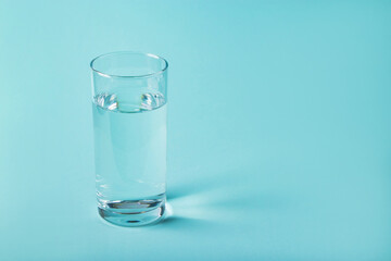 Glass of clear water on a blue background. Health concept.