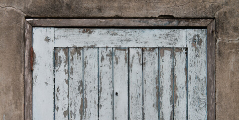 Old wooden plank door with concrete wall
